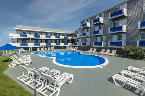 韦斯特利逸景酒店的一座带游泳池和躺椅的度假村和一座建筑