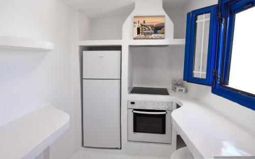 伊利达The Blue and White house in Ioulis, Kea的白色的厨房配有炉灶和冰箱。