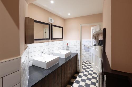 滨海索尔海姆The Crabtree Inn的一间带两个盥洗盆和 ⁇ 格地板的浴室