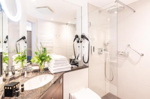 塞巴特阿尔贝克阿尔贝克奥斯酒店的白色的浴室设有水槽和淋浴。
