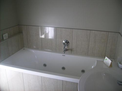 汉密尔顿雅柏阁汽车旅馆的浴室设有浴缸和水龙头