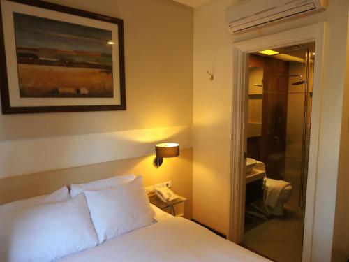 美岸芬南城酒店 的酒店客房设有一张床,墙上挂着一张照片
