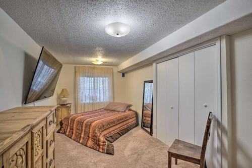 威利斯顿Williston Apartment with Missouri River Views!的一间卧室配有一张床、一个梳妆台和电视。