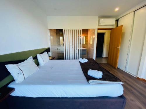 维埃拉·多米尼奥Dobau casas的卧室配有带白色枕头的大床