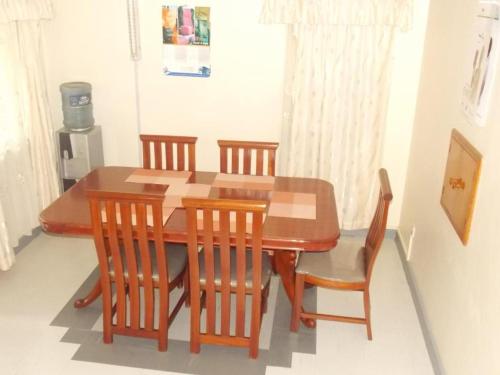 内罗毕Baraka Home的木制餐桌,配有四把椅子和桌子