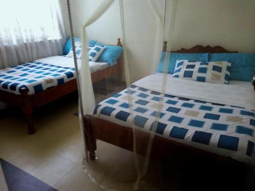 内罗毕Baraka Home的蓝色和白色的客房内的两张床