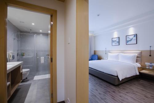 哥印拜陀IKON By Annapoorna的一间卧室配有一张床,浴室设有淋浴。