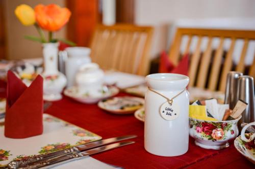 卡迪夫塔内斯酒店的红色桌布上带白色花瓶的桌子