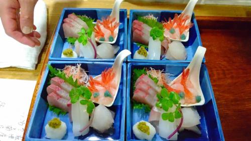 松江市縁の宿 北堀的四个蓝色塑料容器,桌子上装有寿司