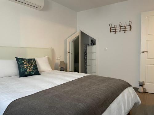 孔佩塔Casa Gato Azul的卧室配有一张带黑色枕头的白色床