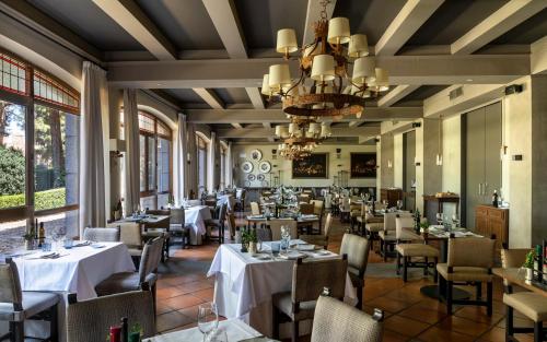 阿维拉帕拉多阿维拉酒店的一间带桌椅和吊灯的餐厅