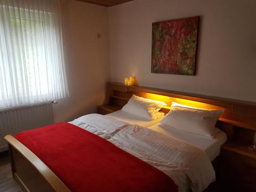 施马伦贝格Gasthof-Pension Hunaustuben的一间卧室配有一张带红色毯子的大床