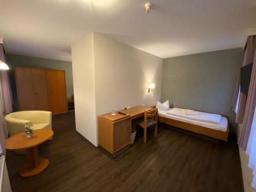 Rechenberg-BienenmühleNaturhotel Lindenhof的配有一张床、一张桌子和一张桌子的酒店客房