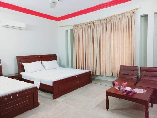 卡拉奇Cosy Inn Guest House Karachi的一间卧室配有两张床、一张沙发和一张桌子