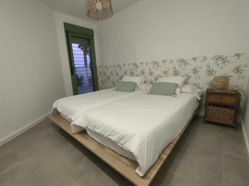 莫哈卡尔Apartamento La Invencible Mojacar 1ª Línea Playa的一间卧室配有一张带白色床单的大床