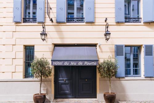 凡尔赛若德鲍姆酒店的一座建筑,有黑色的门和读酒店标志,浪漫法则