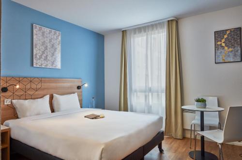 塞纳河畔伊夫里巴黎奎爱艺瑞爱达格公寓式酒店的一间设有大床和窗户的酒店客房