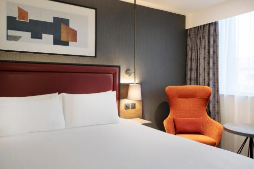 伯明翰Leonardo Royal Hotel Birmingham的配有一张床和一把椅子的酒店客房