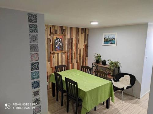 纳塔列斯港Casa 5-6 Personas Puerto Natales的一间带绿色桌椅的用餐室