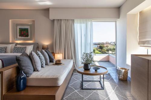 罗德岛卡利地亚Eden Roc Resort - All Inclusive的一间卧室配有一张床、一张沙发和一个窗口