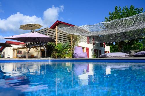 AzurThe Secret Spot Lodge的一个带蓝色水和遮阳伞的游泳池