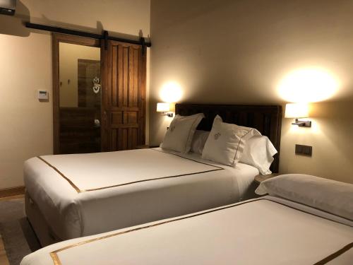 纳瓦尔卡内罗Hotel Boutique Casa del Comendador的一间卧室配有两张床和镜子