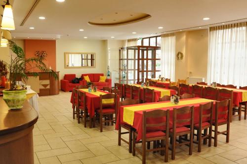 特尔斐卡斯特里酒店的一间设有红色桌子和红色椅子的餐厅