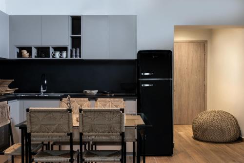 特里卡拉Macrame Luxury Suites的厨房配有桌子和黑冰箱。