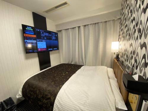 丰桥市APA Hotel Toyohashi-Ekimae的配有一张床和一台平面电视的酒店客房