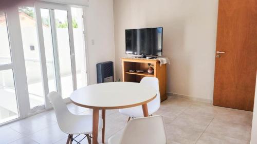 圣罗莎Poas - Alquiler temporario的带电视的客房内的白色桌椅