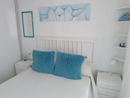 佩尼斯科拉Apartamento El Príncipe的一张带两个蓝色枕头的白色床