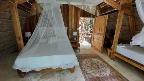El ValleEl Valle Lodge的一间卧室配有一张带蚊帐的床