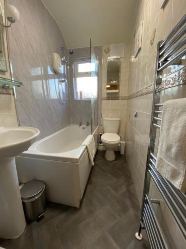 利兹Spacious Stylish Residence的带浴缸、卫生间和盥洗盆的浴室