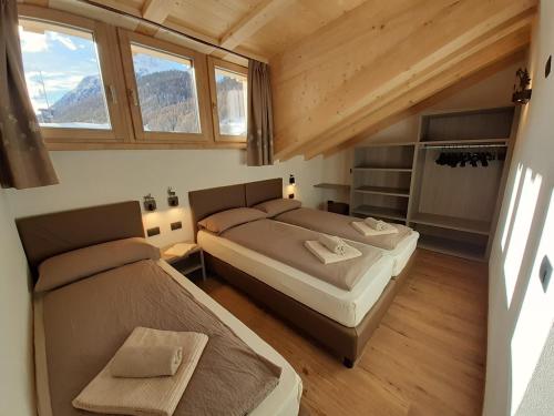 利维尼奥Appartamenti Florin的小型客房设有2张床和窗户。