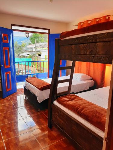 萨兰托Km0 Hostel的一间带三张双层床的卧室和一个阳台