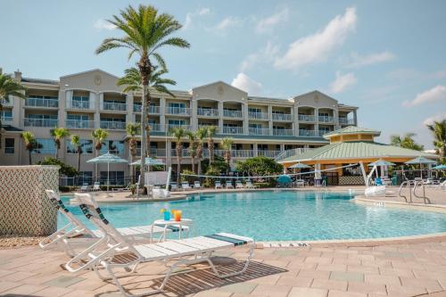 卡纳维拉尔角假日旅馆俱乐部卡纳维拉尔角海滩度假酒店的一个带椅子的度假游泳池和一间酒店