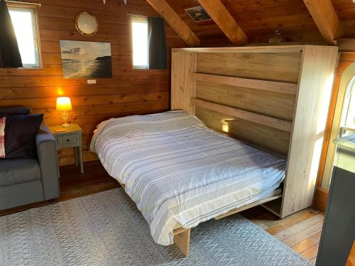 PorkellisEnys Boathouse的小木屋内一间卧室,配有一张床