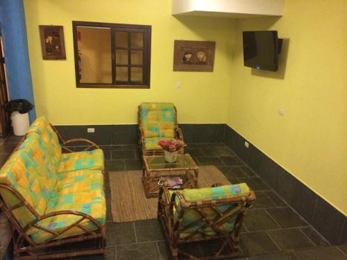 伊利亚贝拉达伊亚酒店的客厅配有两把椅子和电视
