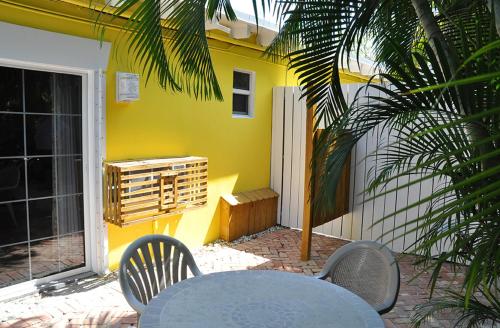 伊斯拉莫拉达The Ocean View Inn的黄色房子前面的一张桌子和椅子
