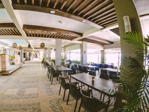 莫龙Miami Heat Beach Resort powered by Cocotel的用餐室配有桌椅和植物