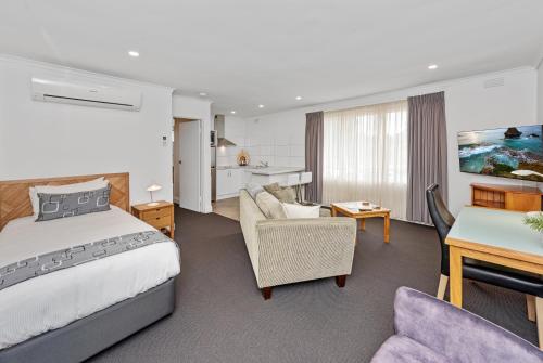 墨尔本Fawkner Executive Suites & Serviced Apartments的酒店客房设有床和客厅。