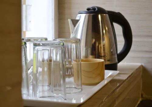 潘奇加尼Citadel Resort的两个玻璃瓶和一个柜台上的咖啡壶