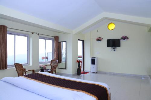 马迪凯里kollanoor guest house的卧室配有一张床,墙上配有电视。