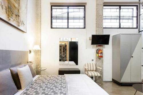 塞维利亚MonKeys Apartments Luxury MetaLoft的一间卧室配有一张床,并在一间客房内配有电视。