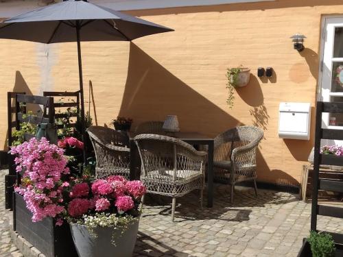 里伯HosHelle的庭院设有椅子和遮阳伞,鲜花盛开