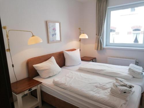 韦斯特兰Sylter-Besserburg-App-6的酒店客房设有两张床和窗户。