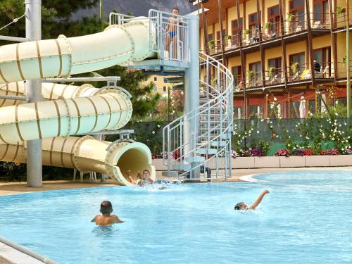 加尔达湖滨加尔达运动俱乐部酒店的一群人在度假村的游泳池游泳