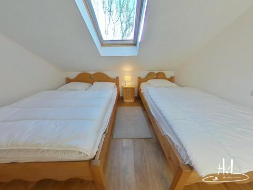 旺特龙Chalet des Chauproyes的带窗户的客房内设有两张单人床。