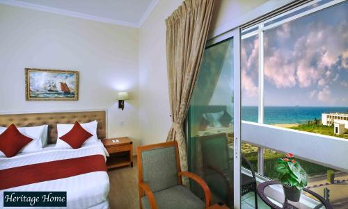 沙迦阿尔塞夫酒店的一间卧室设有一张床和一个享有海景的窗户。