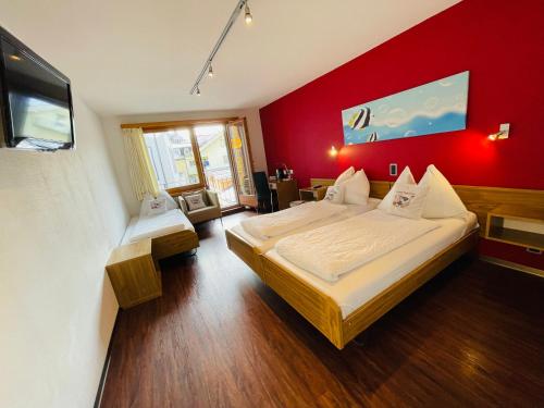 因特拉肯托斯卡纳酒店的一间卧室设有两张床和红色的墙壁
